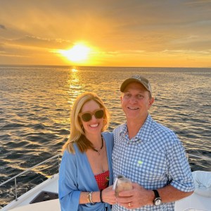 a man and woman sitting next to a body of water