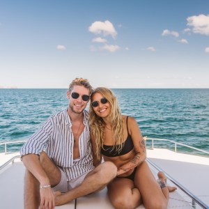 a man sitting next to a body of water