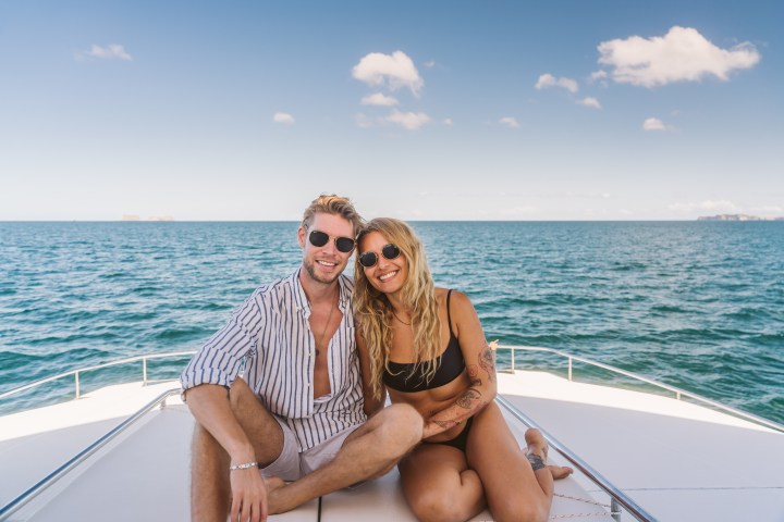 a man sitting next to a body of water