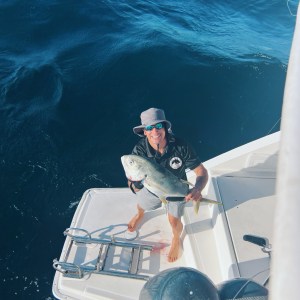 a man riding on the back of a boat in the water