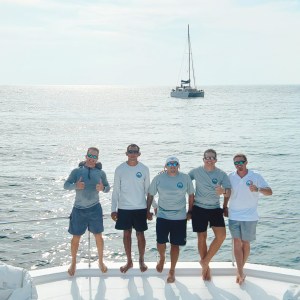 a group of people on a boat posing for the camera