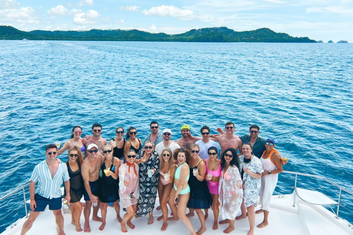 a group of people standing next to a body of water