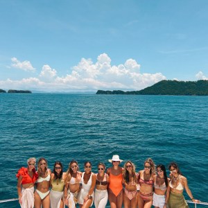 a group of people posing in front of a body of water