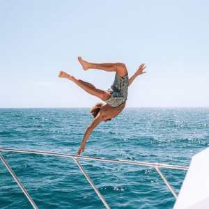 a man flying through the air while riding a surfboard in the water